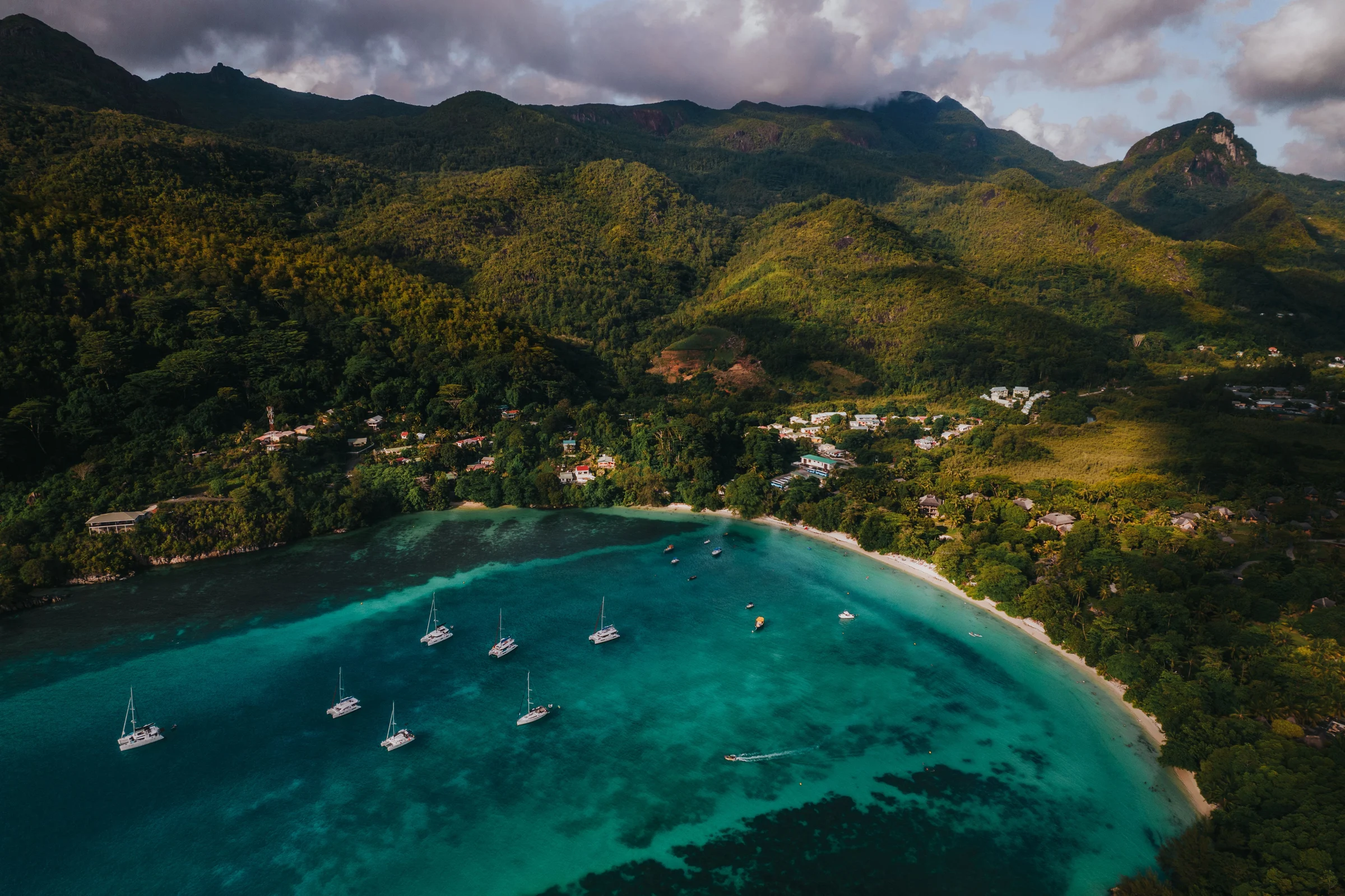 Sailboats in Port Launay bay on Mahé, backed by forested mountains